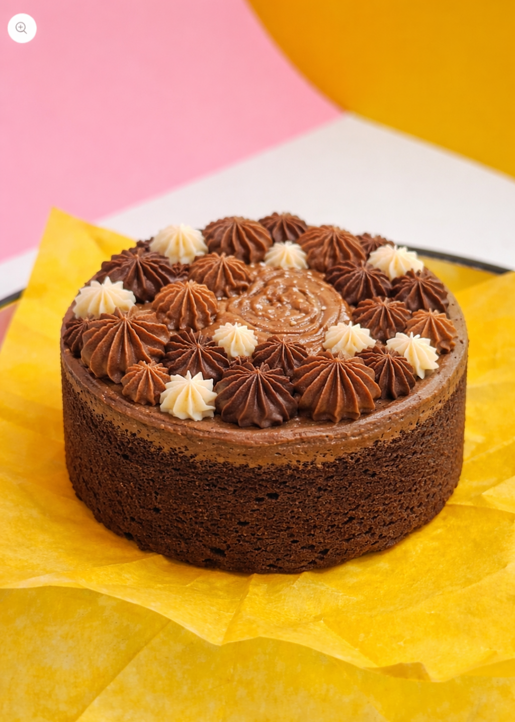 Chocolate cake with star-shaped frosting on a yellow paper background